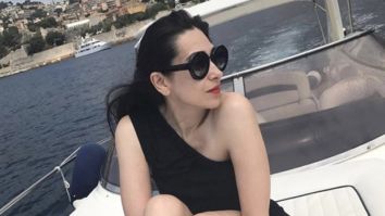 Karisma Kapoor is hotness overloaded in a sultry black off-shoulder monokini while soaking up the sun on a boat